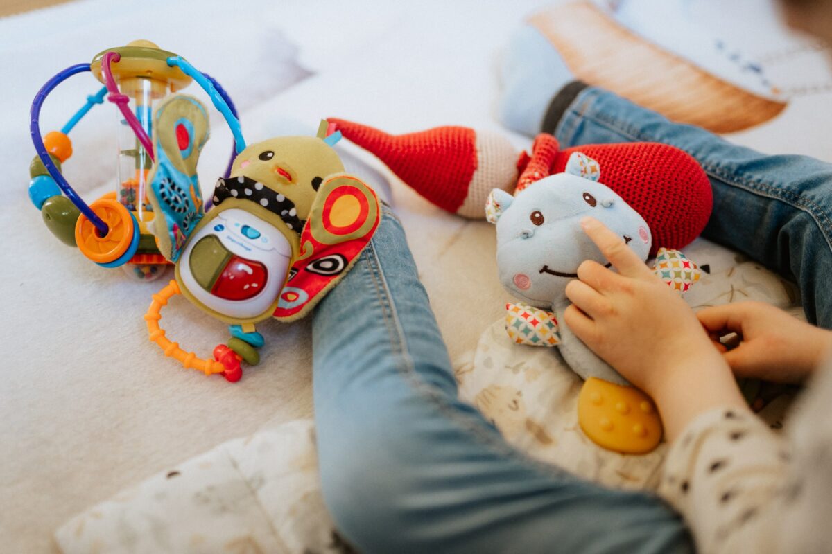 Kuscheltiere und Baby Spielzeug liegen in einem Bett